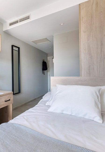 Detalle cama habitación individual residencia en Cartagena