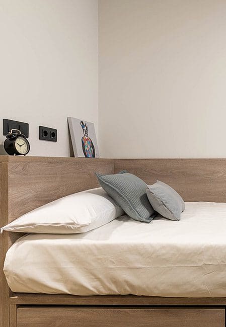 Detalle cama habitación individual en residencia universitaria en Getafe
